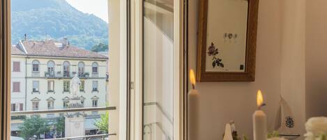 A room with a balcony, a statue, a candle, and a framed picture.