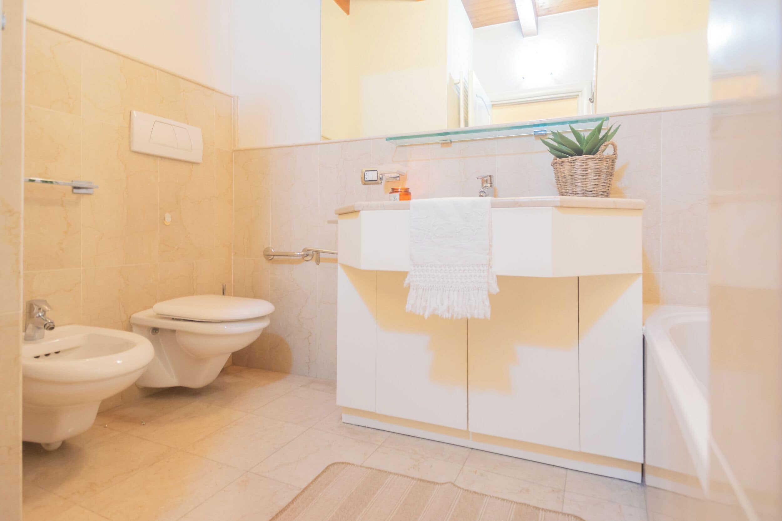 Een moderne badkamer met een witte wastafel, een bidet en een toilet.