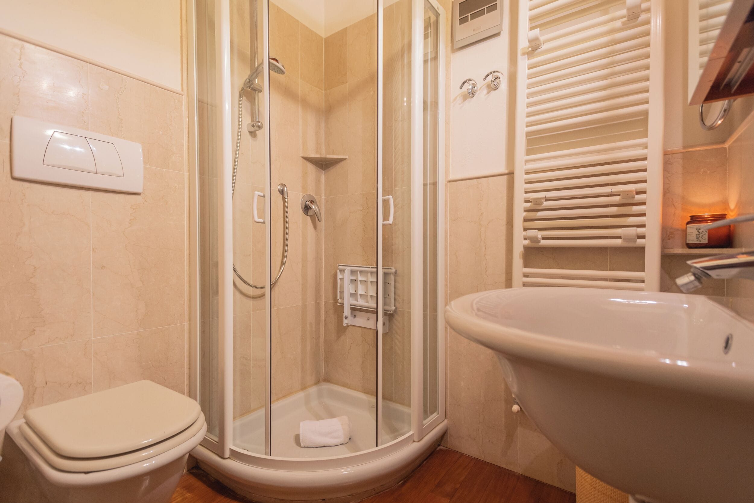Une salle de bain avec une douche à parois de verre, des toilettes et un lavabo sur pied.