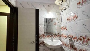 Une salle de bain avec un lavabo, un miroir et une douche.