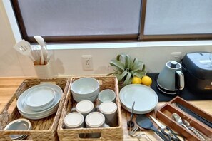 A kitchen area with a window view, a fruit bowl, and various kitchen utensils and dishes. - Cooee Yamanakako (Yamanakako)