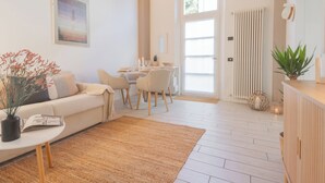 Ein modernes Wohnzimmer mit Sofa, Couchtisch und Essbereich.