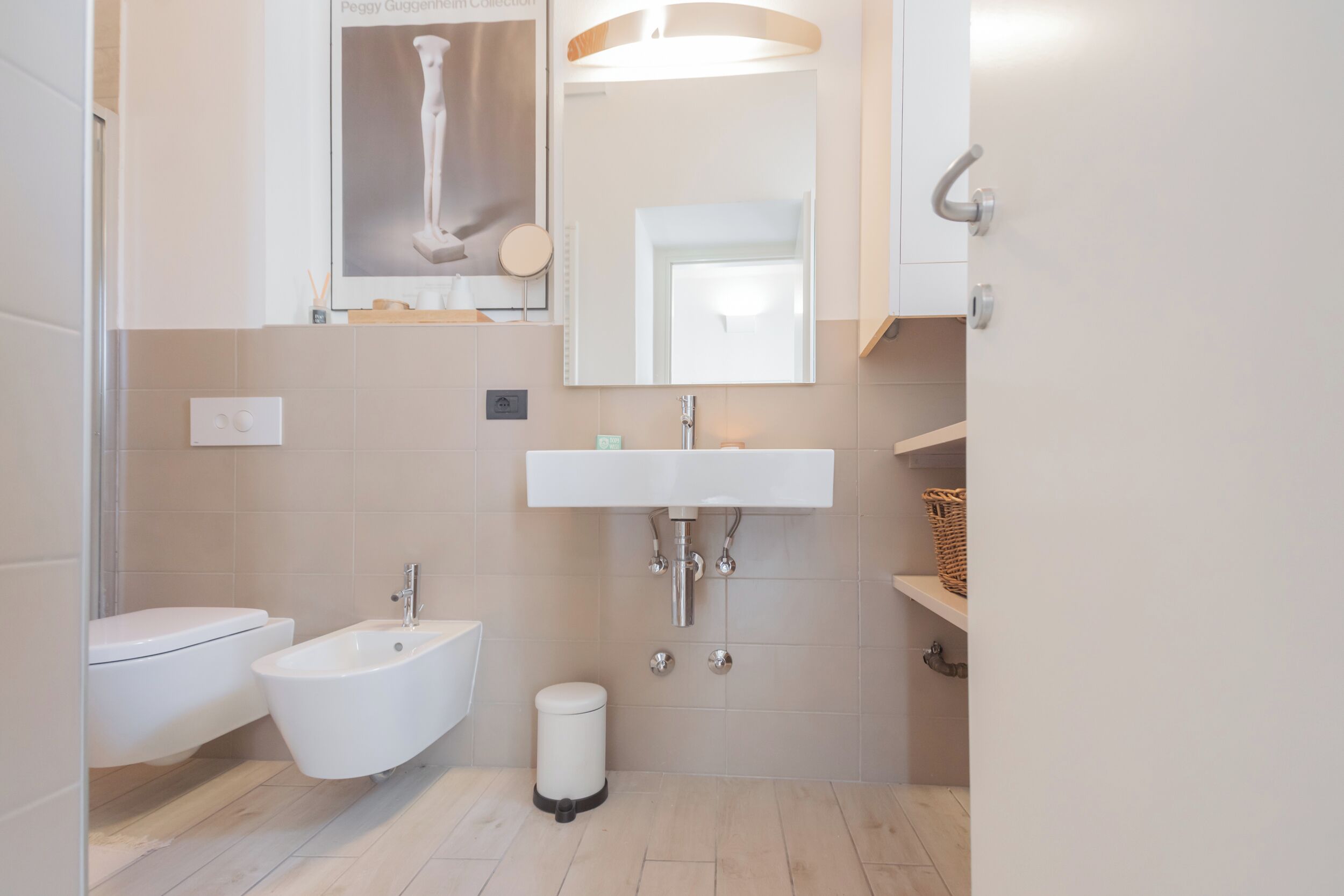 Een moderne badkamer met een toilet, een wastafel en een bidet.