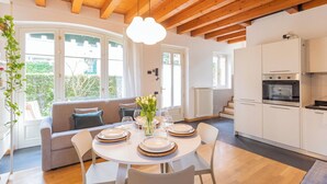 A modern kitchen with white cabinets and a built-in oven. - Vico Garden-203 by Rent all Como (Como)
