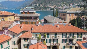 A residential area with terracotta-tiled roofs, green shutters, and a central courtyard with a pool. - Vico Garden-203 by Rent all Como (Como)