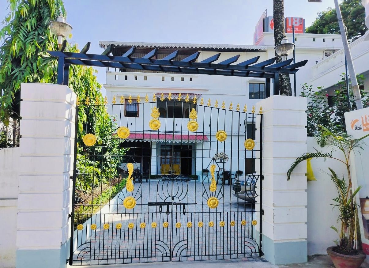 A gated entrance with decorative yellow flowers and a metal gate.