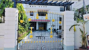 A gated entrance with decorative yellow flowers and a metal gate. - Hotel Insta 18 (Siliguri)
