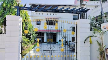 A gated entrance with decorative yellow flowers and a metal gate.