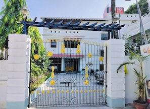 A gated entrance with decorative yellow flowers and a metal gate.