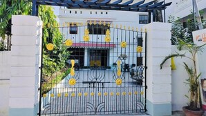 A gated entrance with decorative yellow flowers and a metal gate. - Hotel Insta 18 (Siliguri)