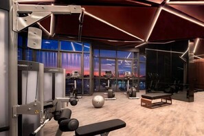 A modern gym with various exercise equipment, large windows, and a view of the cityscape. - Edge Central Pattaya Lux Signature (Pattaya)