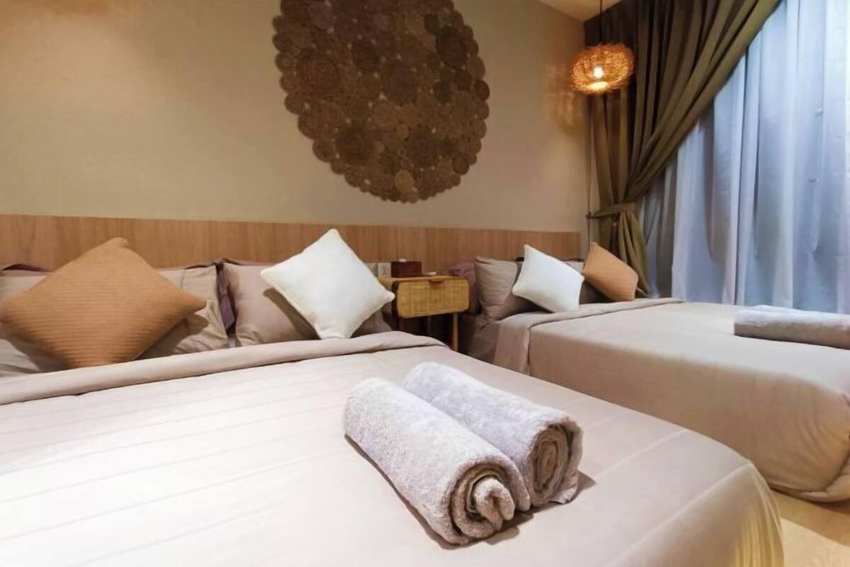 Ein Hotelzimmer mit zwei Betten, einem Wandbild, einer Lampe und Blick ins Freie.