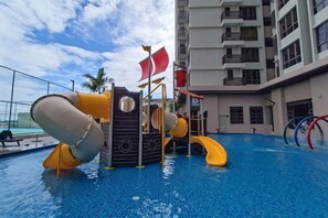 A children's play area with slides and a pirate-themed structure over a swimming pool. - Bali Residence Melaka by Jeffery Lam Home Management (Melaka)