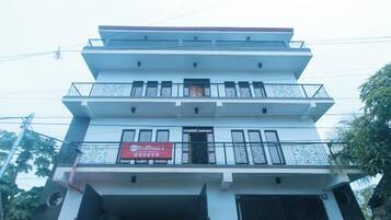 A multi-story building with balconies and a signboard.