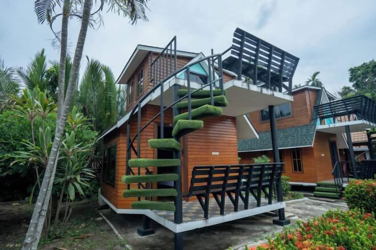 Uma casa moderna com escada em espiral, fachada de madeira e uma varanda.