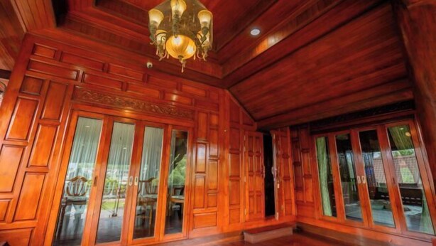 A room with wooden paneling, a chandelier, and large glass doors. - Ban Suan Bang Toei Villa (Sam Phran)