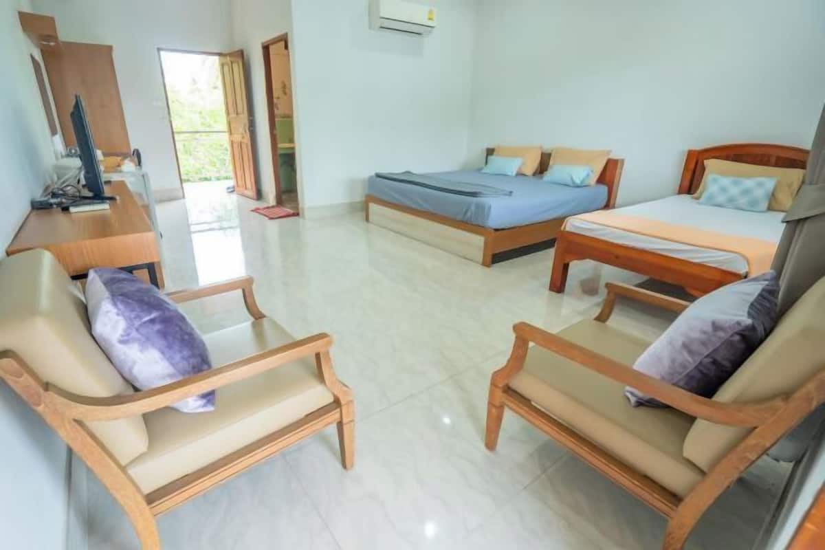 Quarto de hotel com duas camas, uma mesa e duas cadeiras.