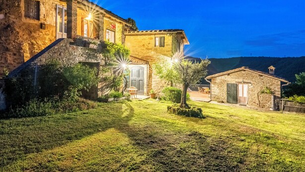 A stone house with a well-maintained lawn and a small garden area. - The Barn apartment in farmhouse with swimming pool surrounded by greenery (Toscana)