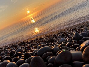 A rocky beach with the sun setting over the water. - Beautiful Period Seaside Home - Budleigh Salterton (Budleigh Salterton)