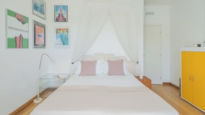 Un dormitorio con cama, mesita de noche, lámpara, armario y decoración en la pared.