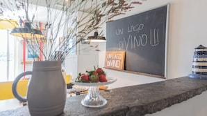 Una encimera de cocina con una jarra de vidrio transparente, un plato de fresas y una pizarra con el texto "UN LAGO DIVINO".