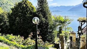 Un sendero de piedra que conduce a un edificio con vista a un lago y montañas.