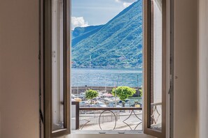 Un balcon offrant une vue sur une marina et un paysage montagneux.