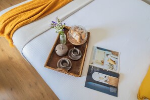 A neatly arranged tray with ceramic tea set, a glass bowl, and a vase with flowers on a white sofa. - Family Nest on Lake Como by Rent all Como (Argegno)