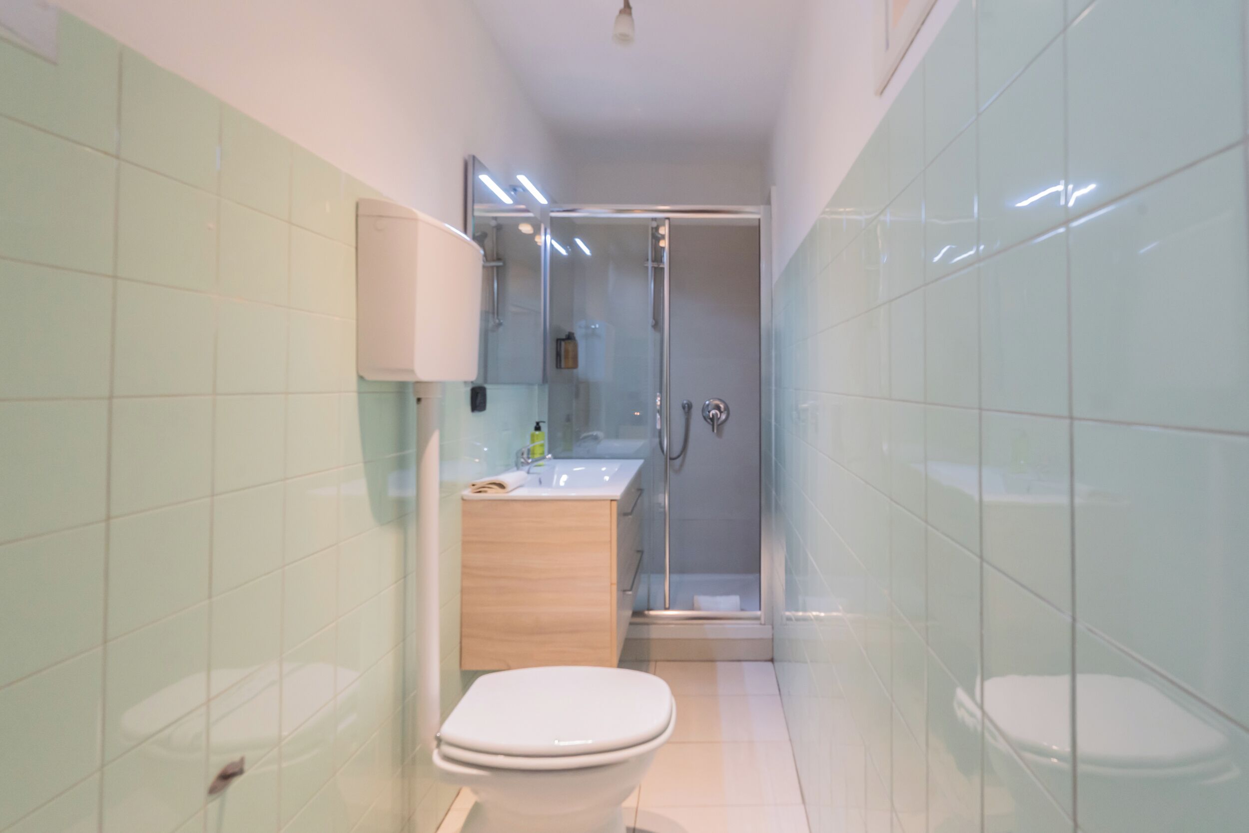 A bathroom with a toilet, sink, and shower.