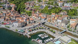 Vue aérienne d’une ville côtière avec un port de plaisance, des bâtiments et un pont.