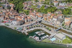 Vista aérea de un pueblo costero con un puerto deportivo, edificios y un puente.