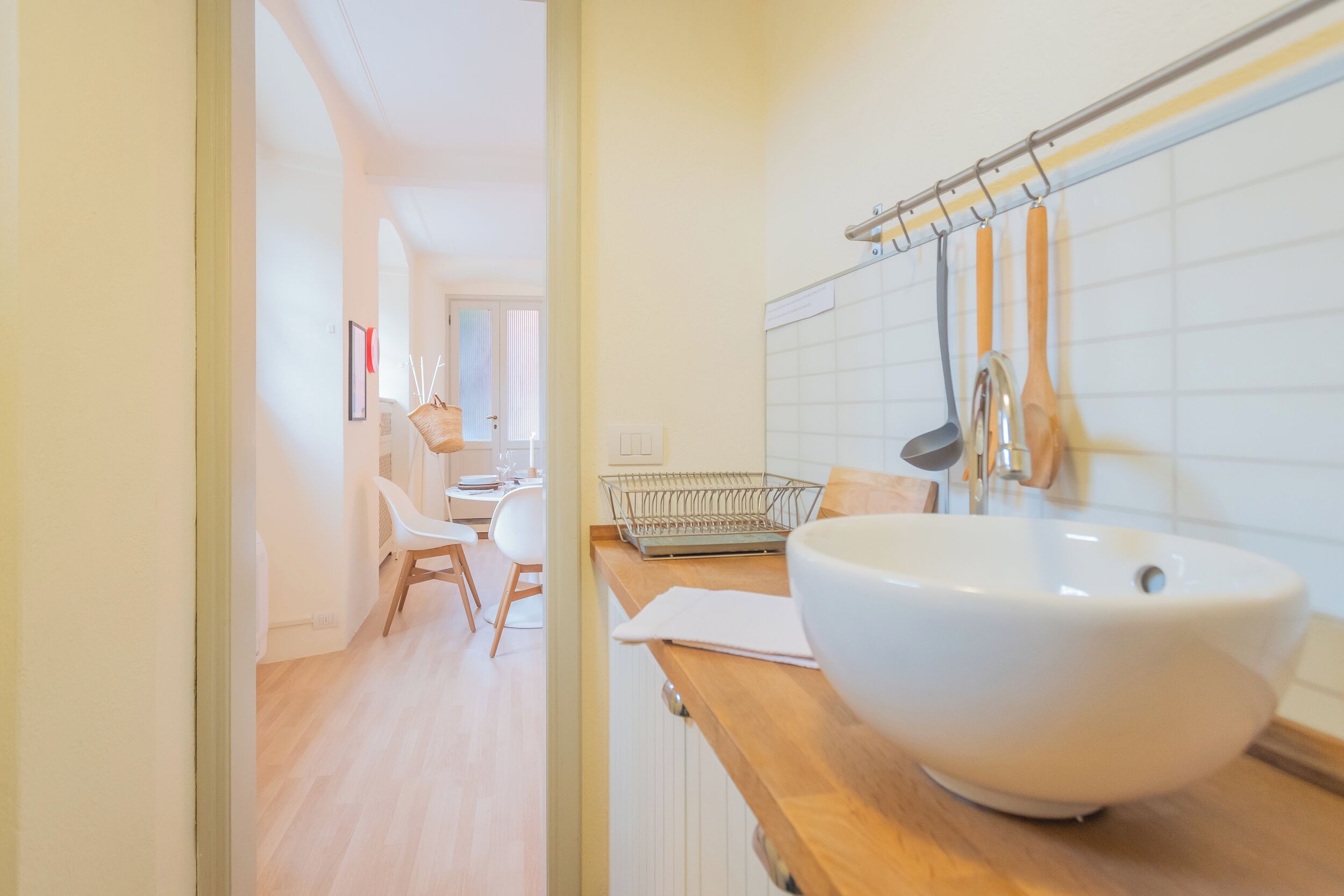 A modern bathroom with a large white sink, wooden countertop, and a towel rack.