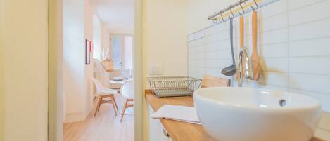 A modern bathroom with a large white sink, wooden countertop, and a towel rack.
