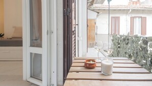 A balcony with a table, a bowl, two glasses, and a candle. - Luce Apartment by Rent all Como (Como)