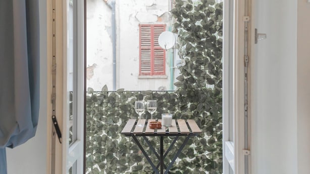 A balcony with a table set for two, featuring a candle and glasses. - Luce Apartment by Rent all Como (Como)
