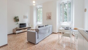 A modern living room with a sofa, TV, and dining table. - Nonna Tere Apartment by Rent all Como (Carate Urio)