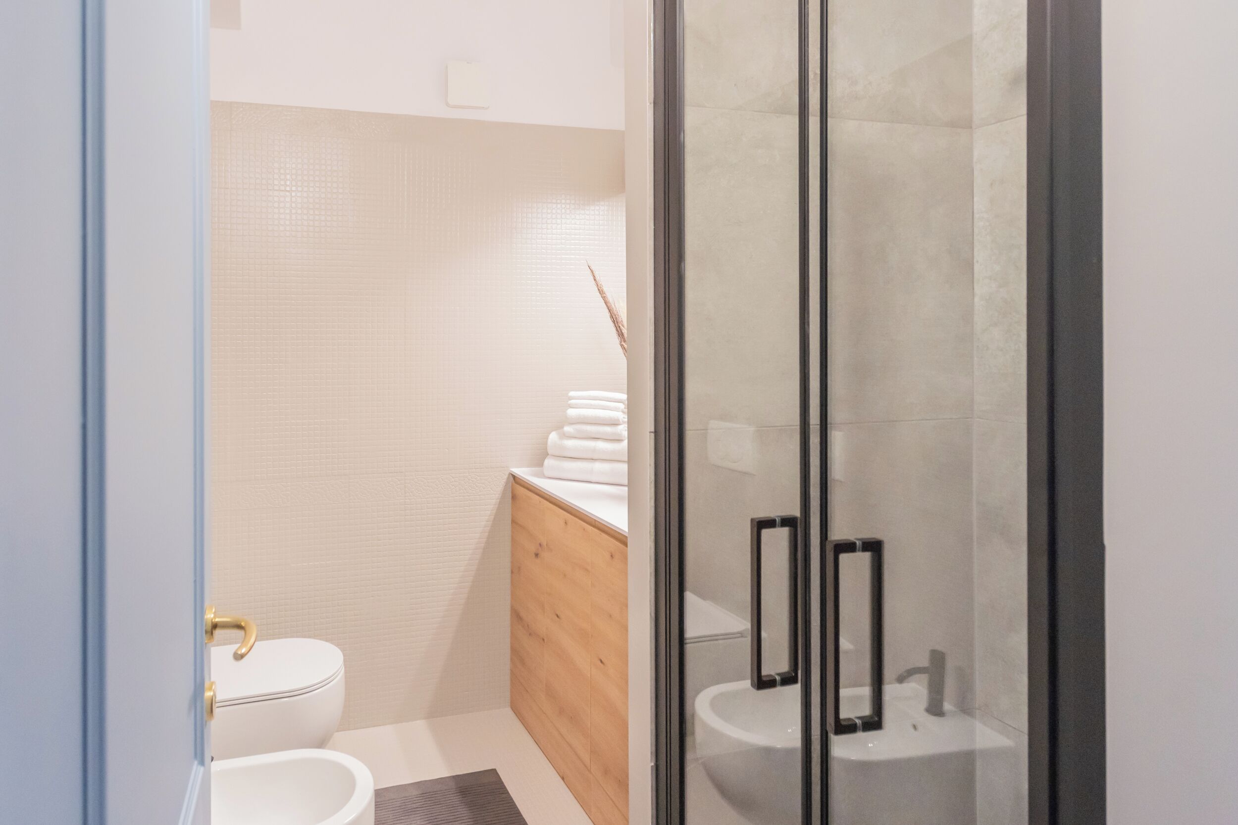 A modern bathroom with a toilet, sink, and shower area.