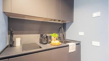 Een moderne keuken met een ingebouwde kookplaat, koffiezetapparaat en een spoelbak.