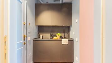 A compact kitchen with dark cabinets, a countertop, and a small sink.