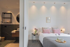 Ein modernes Schlafzimmer mit Bett, Nachttischen und ein Schreibtisch.