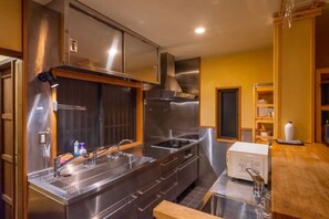 A modern kitchen with stainless steel appliances, wooden cabinets, and a built-in oven. - Shimizu Kozuki 6min walk to Kiyomizu-dera Temple (Kyoto)