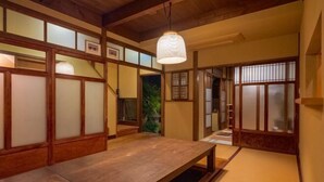 A traditional Japanese room with tatami flooring, a low wooden table, sliding doors, and a hanging light fixture. - Shimizu Kozuki 6min walk to Kiyomizu-dera Temple (Kyoto)