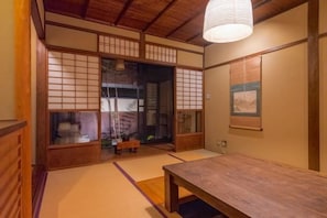 A traditional Japanese room with tatami flooring, a low wooden table, sliding doors, and a hanging light fixture. - Shimizu Kozuki 6min walk to Kiyomizu-dera Temple (Kyoto)
