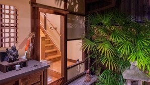 A traditional Japanese-style room with tatami flooring, a shoji screen door, and a small indoor garden with a stone lantern. - Shimizu Kozuki 6min walk to Kiyomizu-dera Temple (Kyoto)