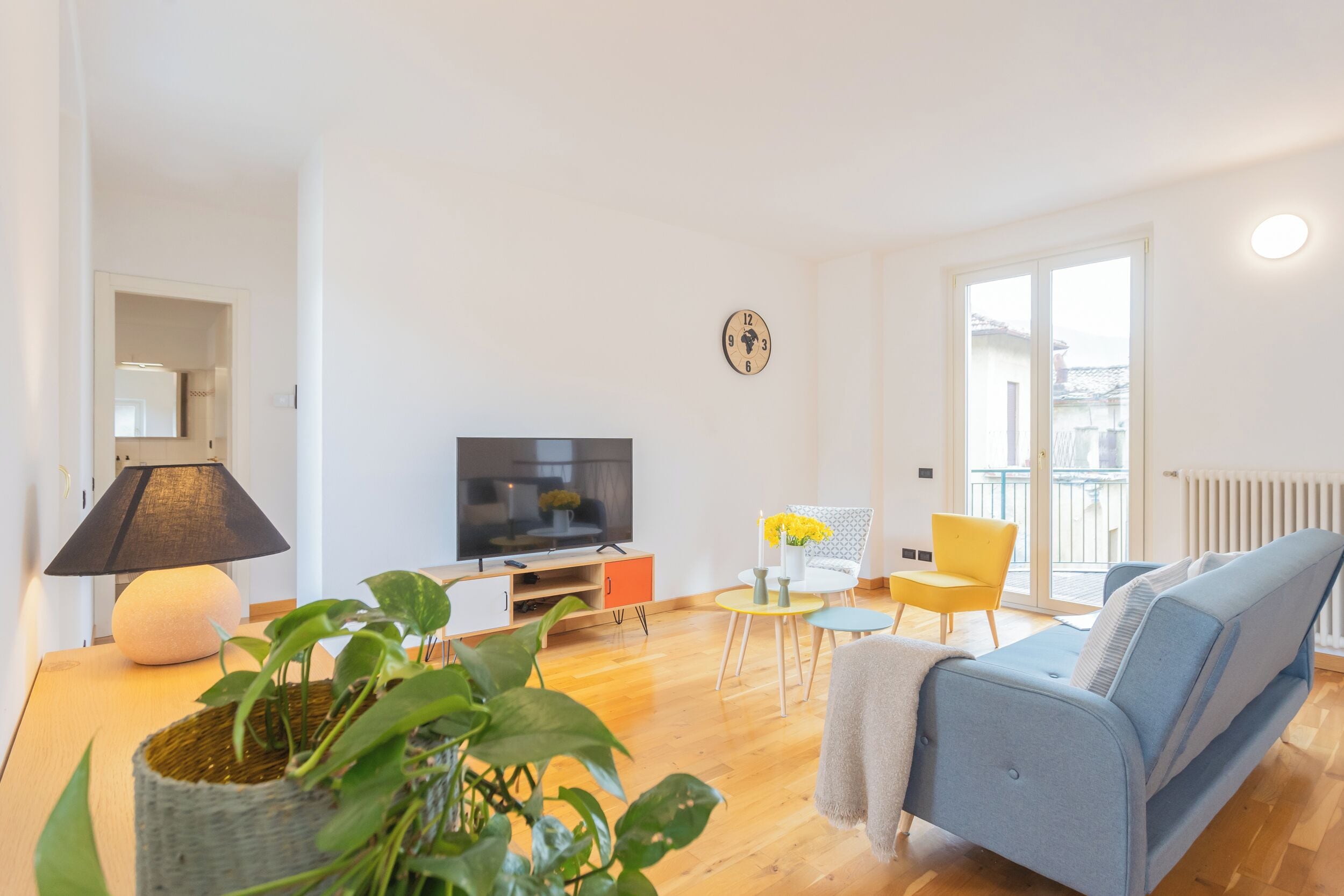 A modern living room with a TV, sofa, and chairs.