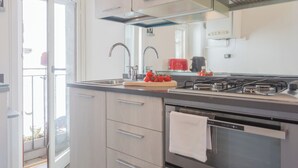 Una cocina moderna con estufa a gas, dos fregaderos y un ventanal amplio.