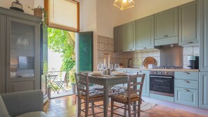 Une cuisine avec un coin repas, comprenant une cuisinière, un four et une table à manger pour quatre personnes.