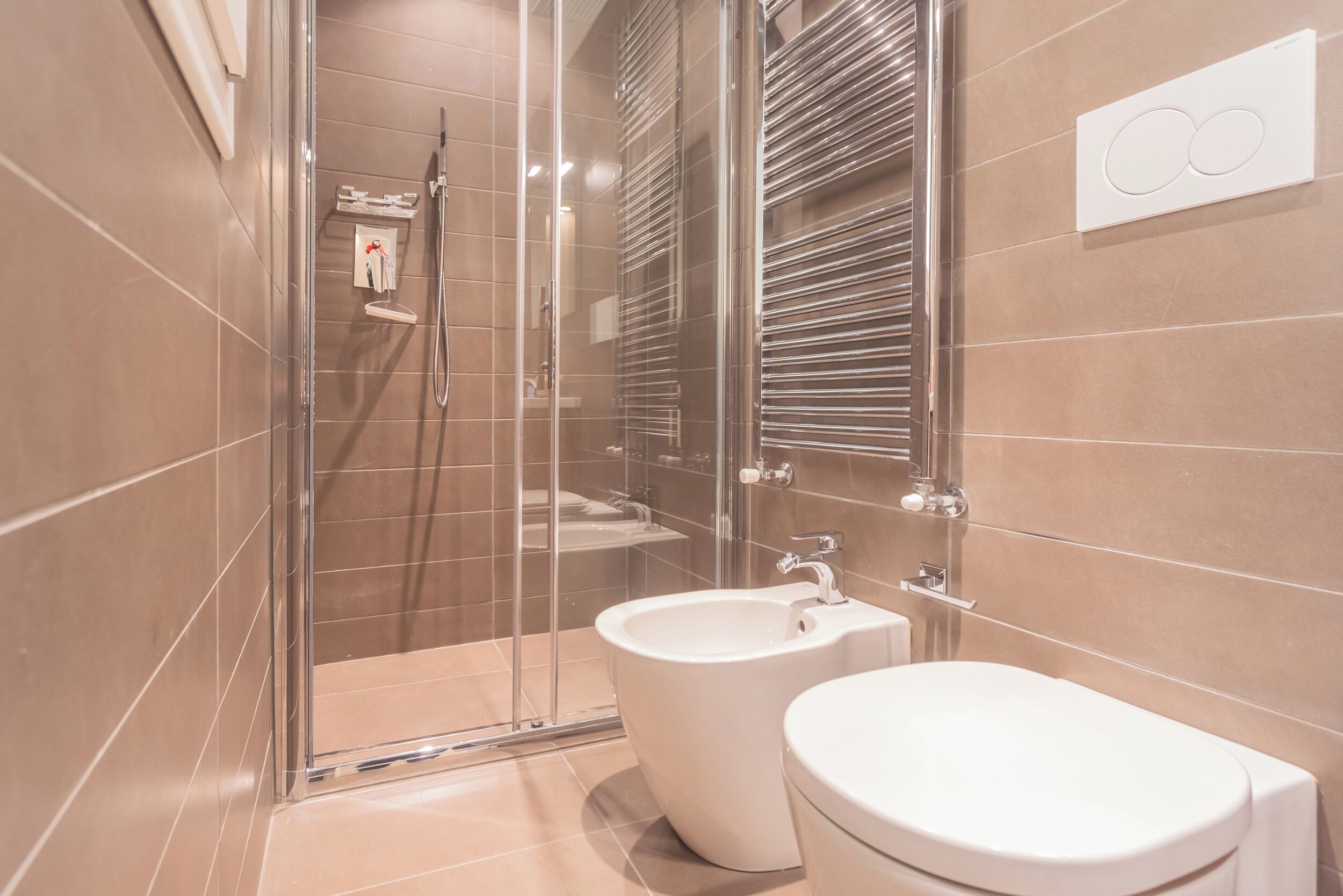 Ein modernes Badezimmer mit einer Duschkabine, einem Bidet und einer Toilette.
