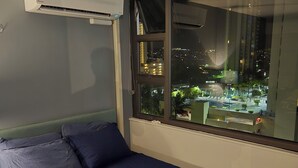 Une chambre à coucher avec un lit, une fenêtre et un appareil de climatisation.