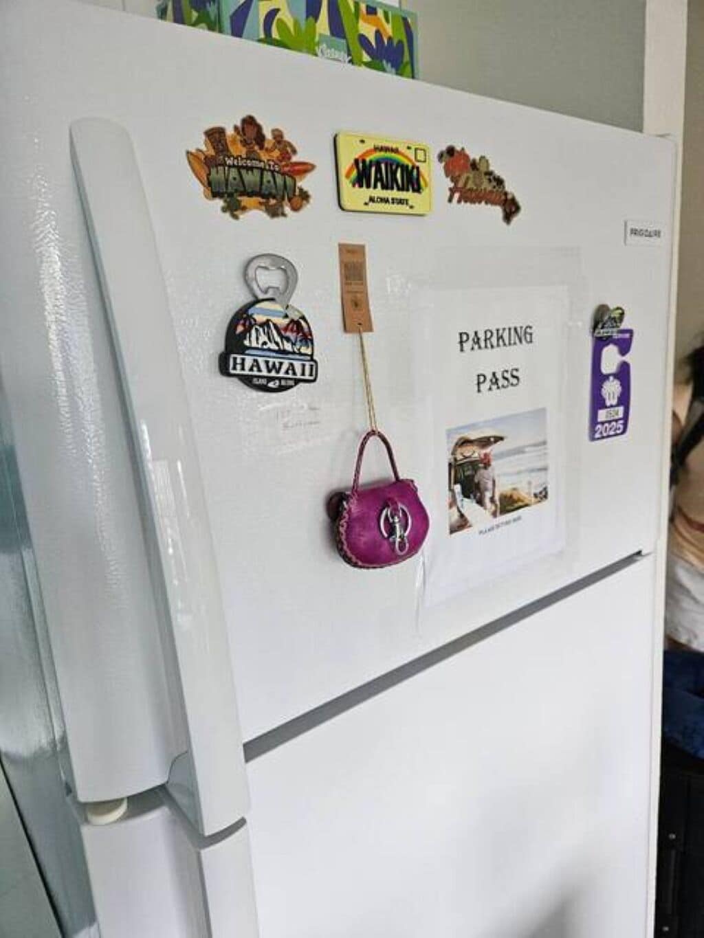 A refrigerator with various magnets and a parking pass.